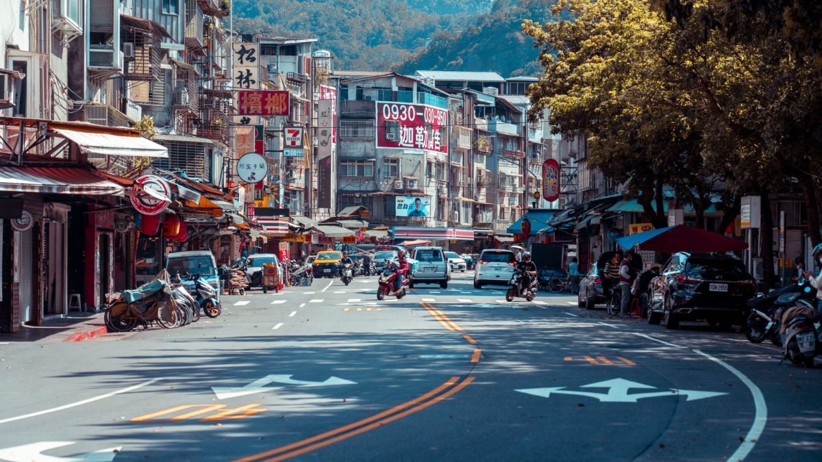 Vibrant urban street scene with shops, vehicles, and mountains in an Asian city. — 5 Steps to Securely Obtain TRT Through Tel
