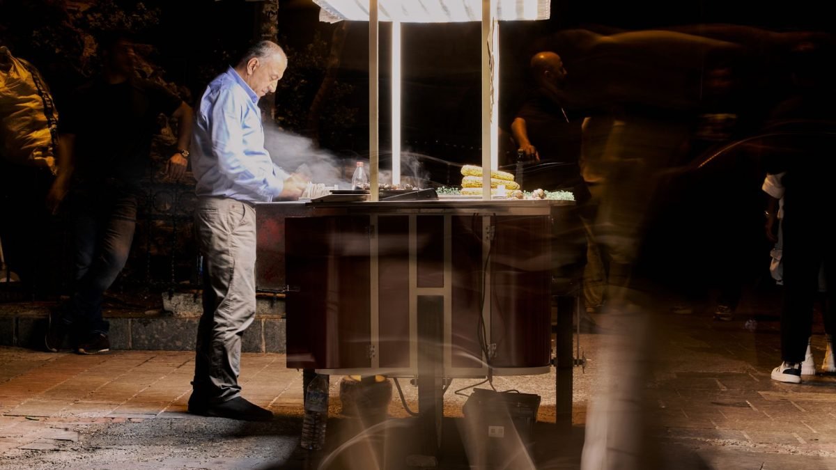 Street vendor cooking food at night with blurred people passing by. — A Guide to 2025 Humana Medicare Advantage Plan Options