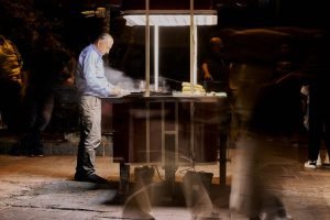 Street vendor cooking food at night with blurred people passing by. — A Guide to 2025 Humana Medicare Advantage Plan Options