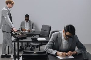 Business office with diverse employees in gray suits working at desks in an indoor setting. — Boost Your Agency's Growth with