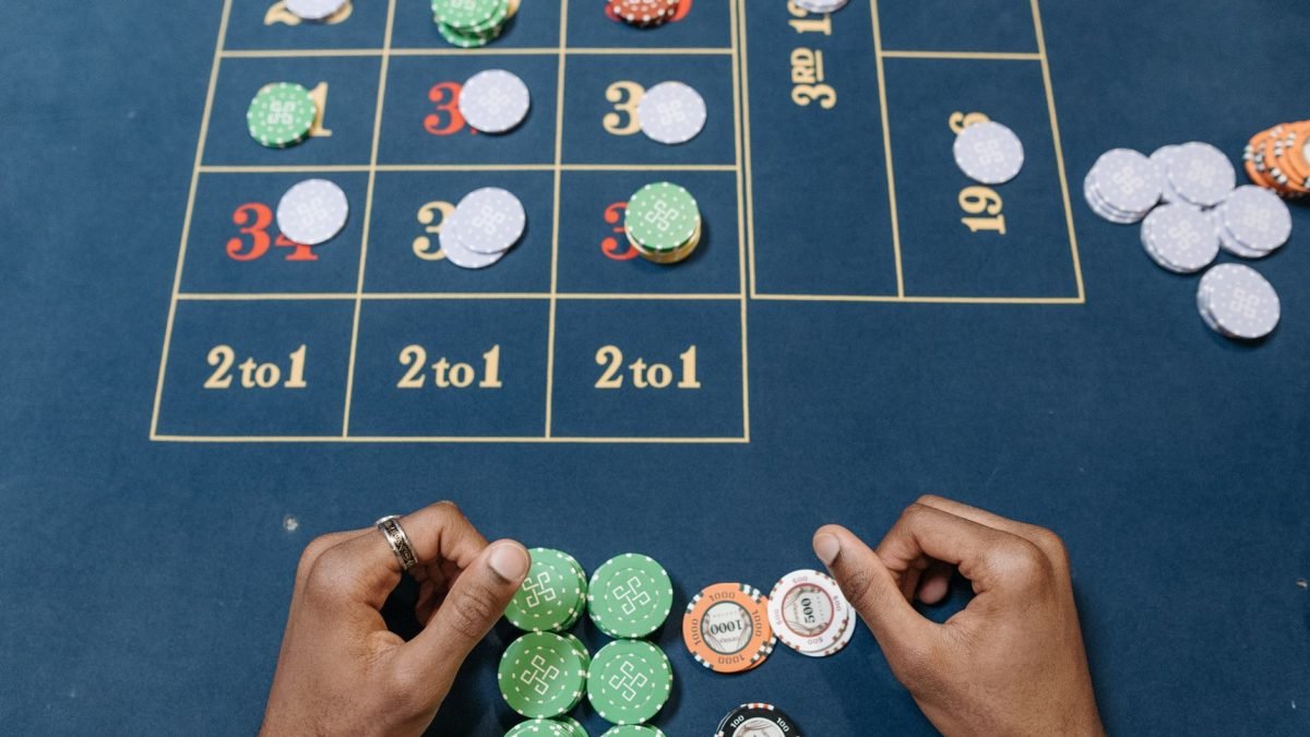Hands arranging poker chips on a colorful casino gaming table, top view. — Cosmic Fortune: Exploring the Galaxy with Casimba