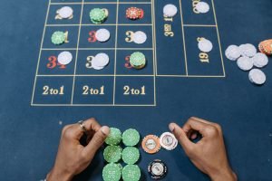 Hands arranging poker chips on a colorful casino gaming table, top view. — Cosmic Fortune: Exploring the Galaxy with Casimba