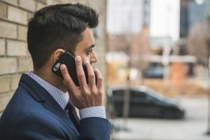 Professional man in suit making a phone call outside in city setting. — Explore the Best Window Options in Doral, FL