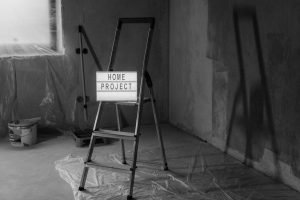Black and white image of a step ladder with a 'home project' sign in a renovation setting. — "Get Top-Tier Window Replacement