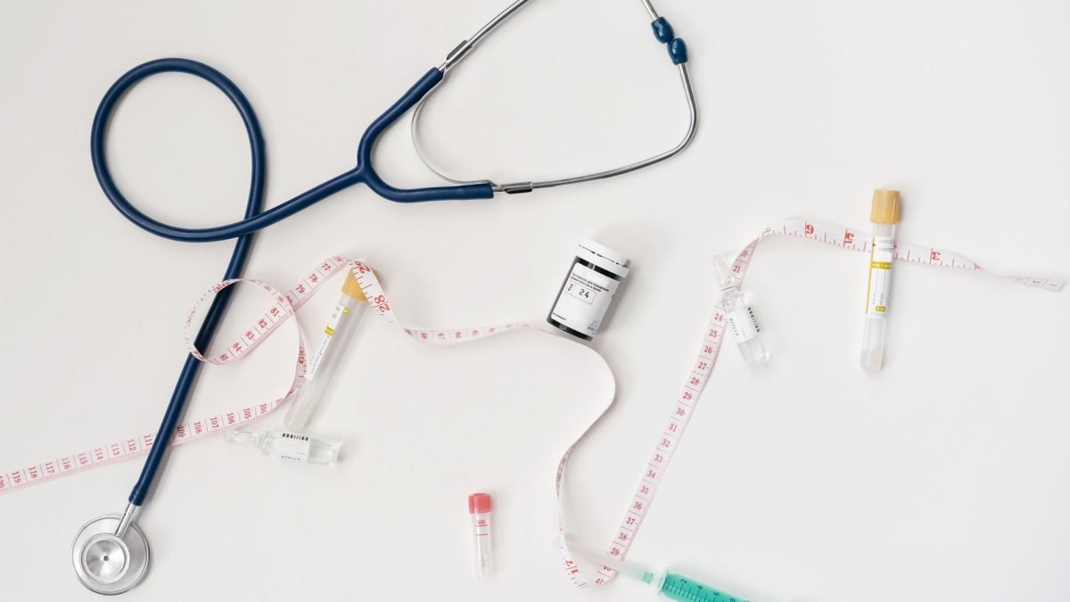 Top view of stethoscope, syringes, and tape measure on white background. — How to Verify the Legitimacy of Online Testosteron