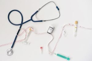 Top view of stethoscope, syringes, and tape measure on white background. — How to Verify the Legitimacy of Online Testosteron