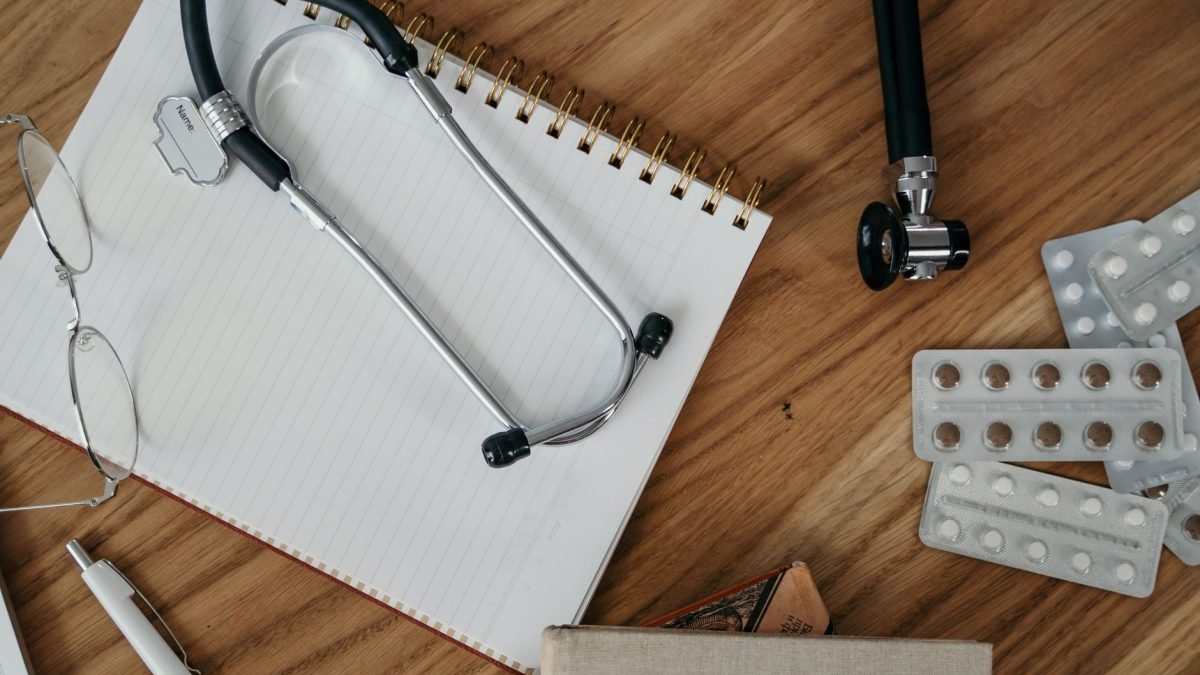 Flat lay of medical tools and supplies on a wooden desk surface. — Minimally Invasive Spine Surgery in Tampa, FL promoting fa