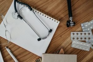Flat lay of medical tools and supplies on a wooden desk surface. — Minimally Invasive Spine Surgery in Tampa, FL promoting fa