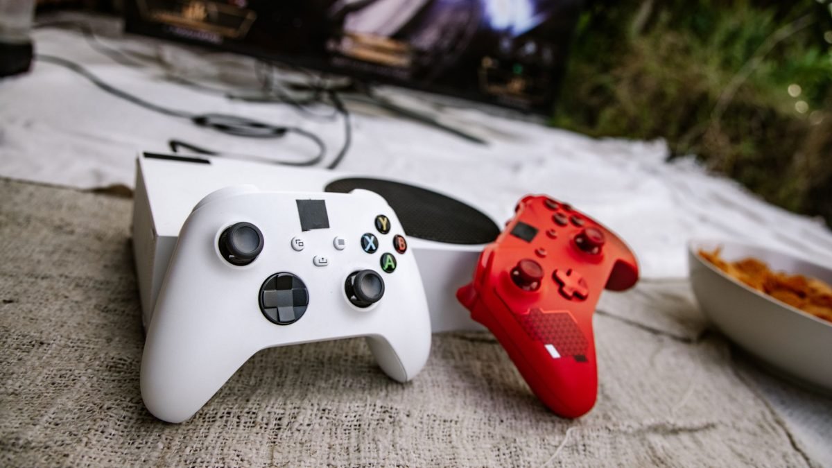 White and red wireless gaming controllers on a textured surface near chips and a TV screen. — No Deposit Casinos Reward You B