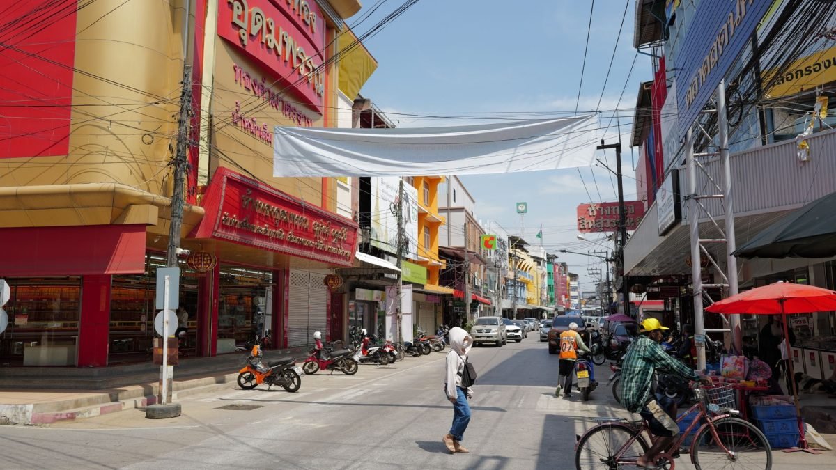 Lively urban street in Thailand with people, shops, and traffic under a sunny sky. — Optimizing Athlete Care and Performance
