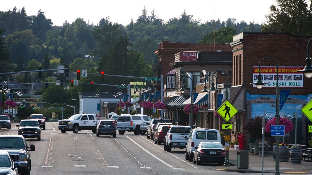 Lively urban street with cars, shops, and pedestrians during daytime. — Rediscover Passion: Tantric Massage Outcalls in Londo