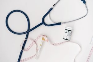 Flat lay of medical tools including stethoscope and measuring tape on a white background. — Strategic Growth and Healthcare E