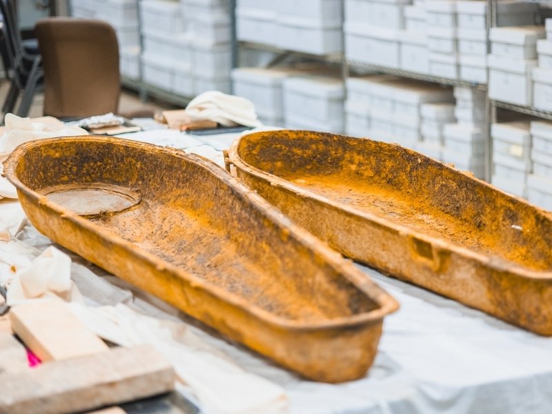 Two rusty old medical stretchers on a table with a blurred background.